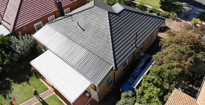 House with perfect metal roof surrounded by green tall tree