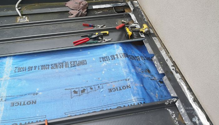 roof repairing process with blue cover sheet and tools 