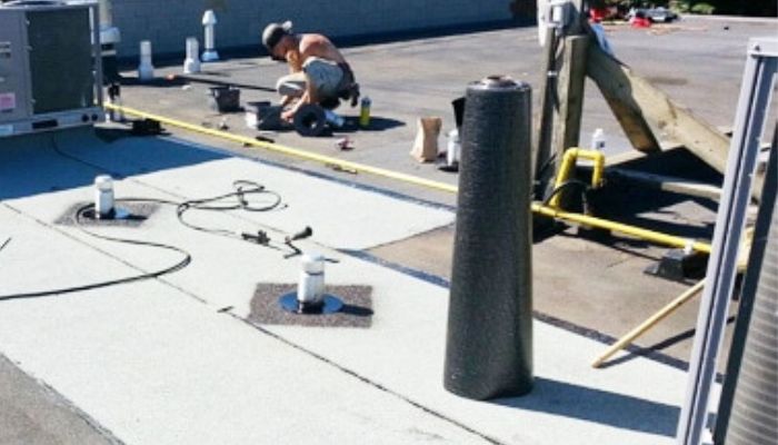 man working on the flat roof for maintenance 