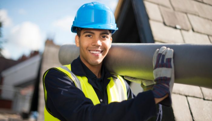 professional roof worker holding the pipe and smiling 