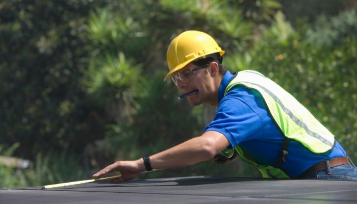 worker measuring roof 