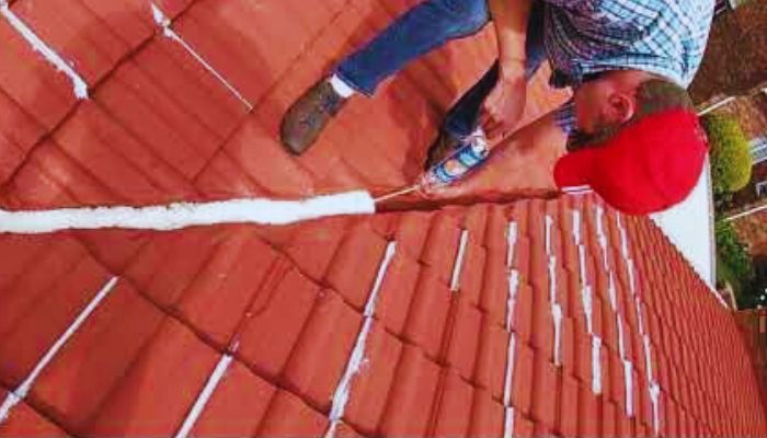 man coating the roof 