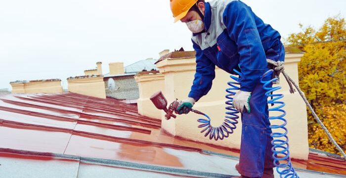 roof worker coating the metal roof